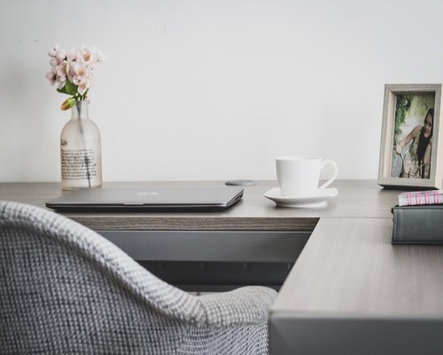 Person stretching arms at home office desk